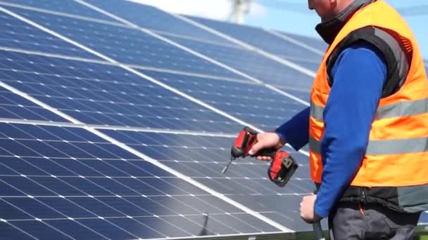Solar Power Plant Worker Standing Stepladder Tightens Solar Panels Fixing — Stock video