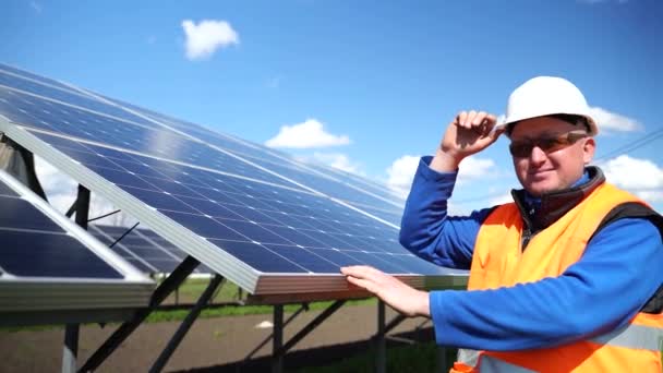 Male Engineer Stands Background Solar Panels Lifting Helmet Looks Camera — Vídeo de Stock