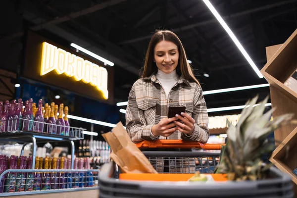 Cheerful Woman Using Mobile Phone While Shopping Supermarket — Stok fotoğraf