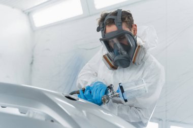 Araba boyacısı bir araba tamponunun yüzeyine cila katmanı uygular. Otomatik servis odasında boyama işi