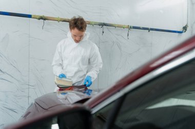 Ressam örneklerde doğru araba boyasını arıyor.