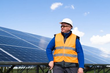 Güneş panelinin arka planında bir erkek elektrik mühendisinin portresi