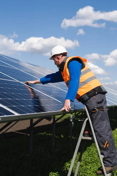 Pracownik Elektrowni Słonecznej Drabinie Schodowej Dokonuje Oględzin Paneli Słonecznych — Zdjęcie stockowe