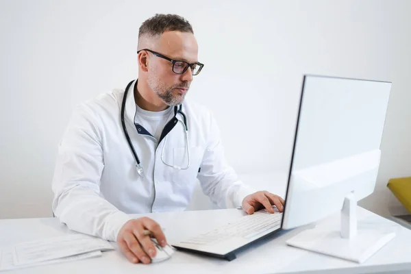Médico Masculino Óculos Vestindo Casaco Branco Com Estetoscópio Sentado Computador — Fotografia de Stock