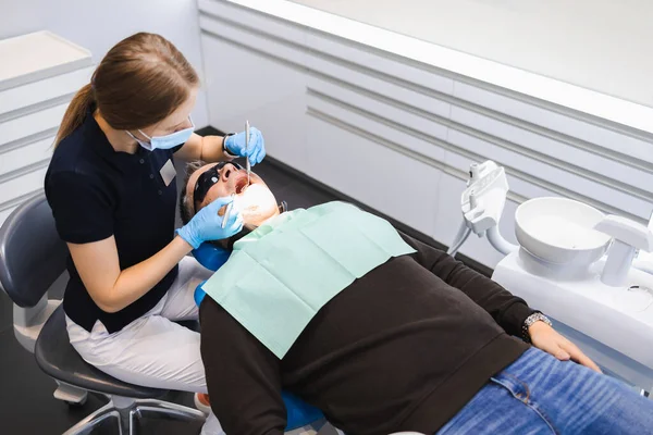 Kadın Doktor Erkek Bir Hastanın Dişlerini Muayene Eder — Stok fotoğraf