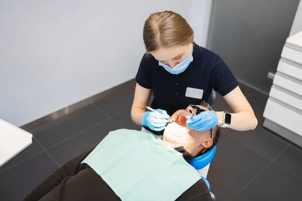 Kadın Doktor Erkek Bir Hastanın Dişlerini Muayene Eder — Stok fotoğraf