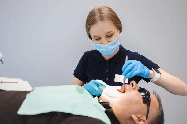 Kadın Dişçi Erkeğin Dişlerini Dolduruyor — Stok fotoğraf
