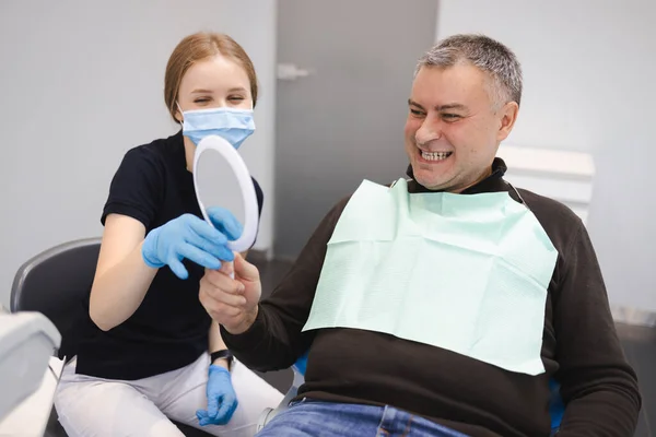 Kadın Dişçi Aynayla Yapılan Diş Tedavisinin Sonucunu Klinikteki Bir Hastaya — Stok fotoğraf