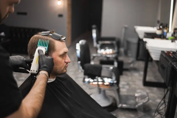 理髪師は男性の顧客のためのファッショナブルなヘアカットを作ります 美容師が男の髪を切って — ストック写真