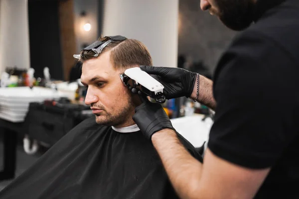 男は理髪店のチャイに座っている間にヘアカットを取得 — ストック写真