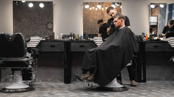男性クライアントのひげそりの美容師の切断髪 — ストック写真