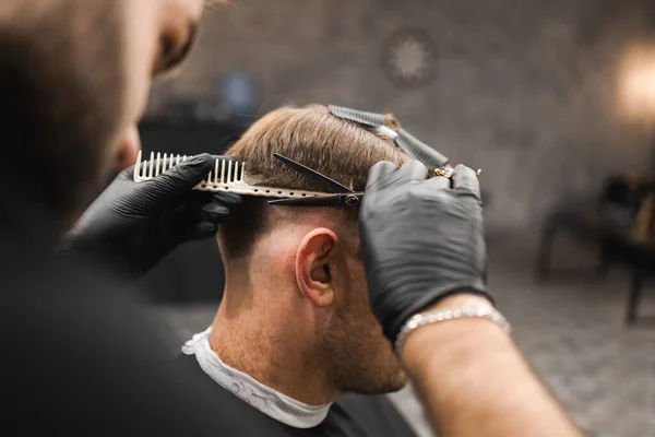 理容室で男性の顧客の髪を切断男性の美容師 — ストック写真