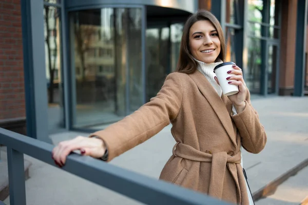 Ικανοποιημένη Νεαρή Γυναίκα Που Κρατάει Ένα Χάρτινο Φλιτζάνι Καφέ Εξωτερικό — Φωτογραφία Αρχείου