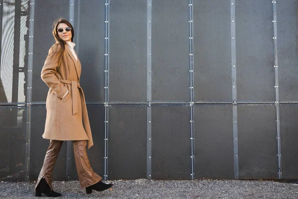 Mulher Elegante Casaco Óculos Sol Caminha Contra Fundo Edifício Moderno — Fotografia de Stock