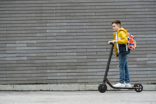 Boy Backpack Rides Electric Scooter Gray Brick Wall — Stock Photo, Image