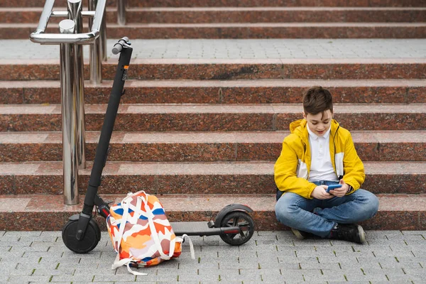 Modern Teenager Uses Smartphone While Sitting Stairs Next His Electric — Stock Photo, Image