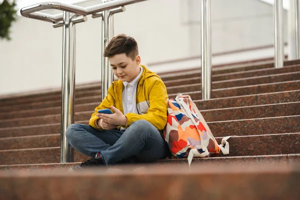 Cute Uczennica Żółtej Kurtce Siedzi Schodach Używa Smartfona — Zdjęcie stockowe