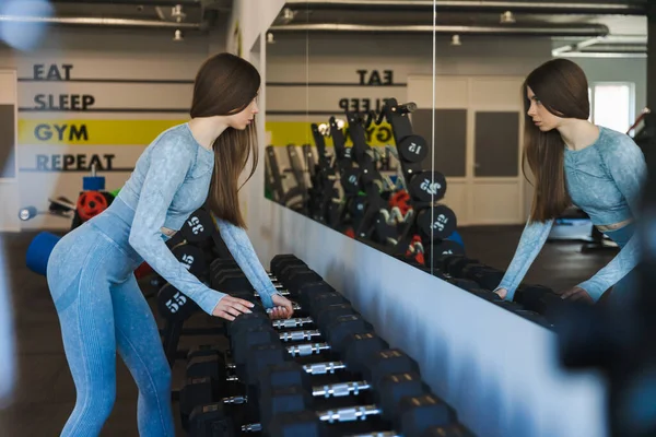 Linda Chica Tomando Una Mancuerna Estante Gimnasio — Foto de Stock