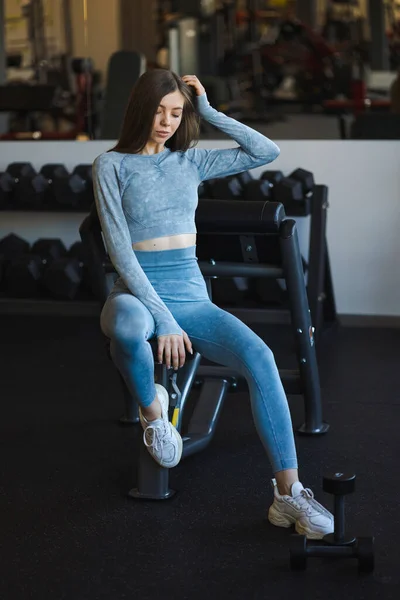 Atractiva Chica Fitness Chándal Azul Posando Mientras Está Sentado Gimnasio — Foto de Stock
