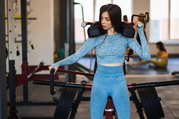 Chica Fitness Gimnasio Utiliza Una Máquina Sentadilla — Foto de Stock