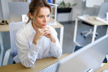 Bilgisayar ekranına bakarak ciddi iş kadını