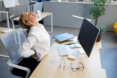 Ofiste sırtı ağrıyan orta yaşlı iş kadını portresi