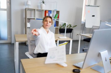 Kızgın kadın patron birine belge atıyor.