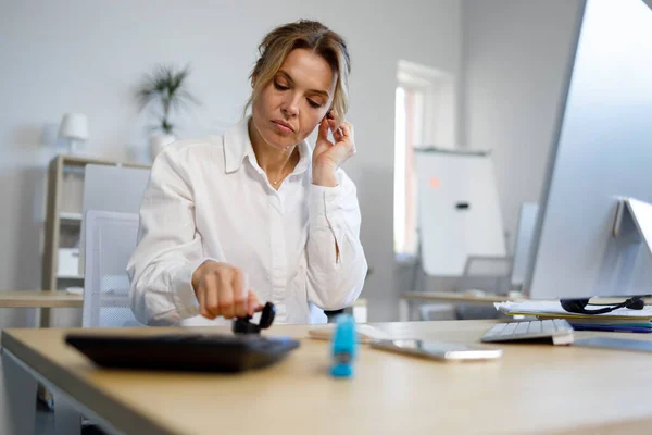 Female Office Worker Putting Wireless Headphones — Zdjęcie stockowe