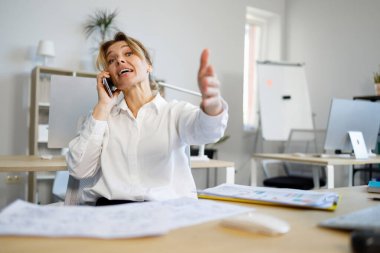Duygusal iş kadını telefonda konuşuyor ve elini kameraya doğrultuyor.