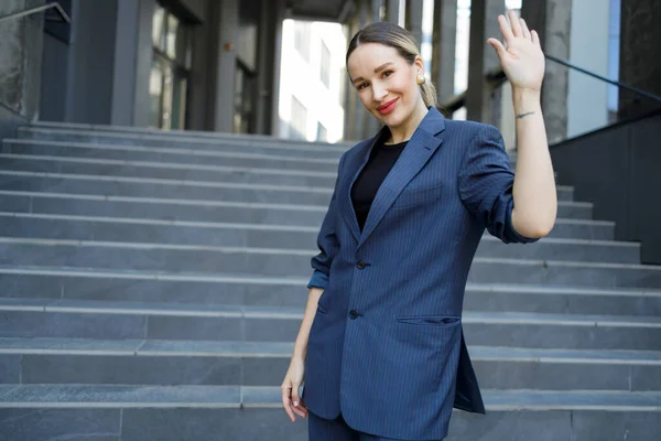 Business woman waving hand outdoors
