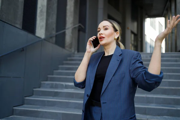 ビジネスセンタービルの近くの電話で話すエレガントな女性 — ストック写真