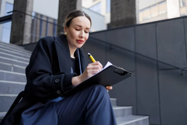 クリップボードに書き込みビジネス女性屋外 — ストック写真