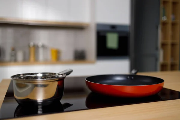 Empty frying pan and sauce pan on induction cooktop