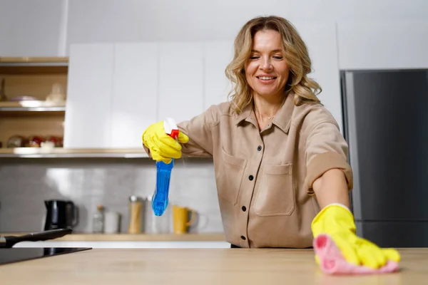 Mulher Pulverizando Limpador Desinfetante Bancada Cozinha Madeira Durante Limpeza Casa — Fotografia de Stock