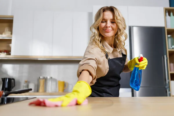 Wanita Paruh Baya Yang Menyenangkan Membersihkan Meja Dapur Dengan Kain — Stok Foto