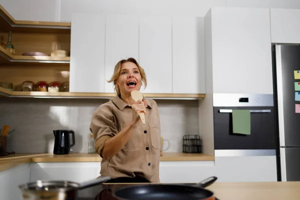 Volwassen Vrouw Kookt Eten Keuken Zingt Met Behulp Van Een — Stockfoto