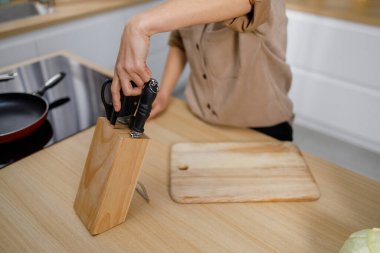 Tanımlanamayan bir kadın yemek yapmaya başlamadan önce mutfaktan bir bıçak çıkardı.