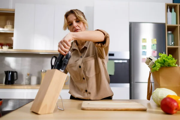 Mujer Madura Cocina Toma Cuchillo Del Bloque Ama Casa Preparándose — Foto de Stock