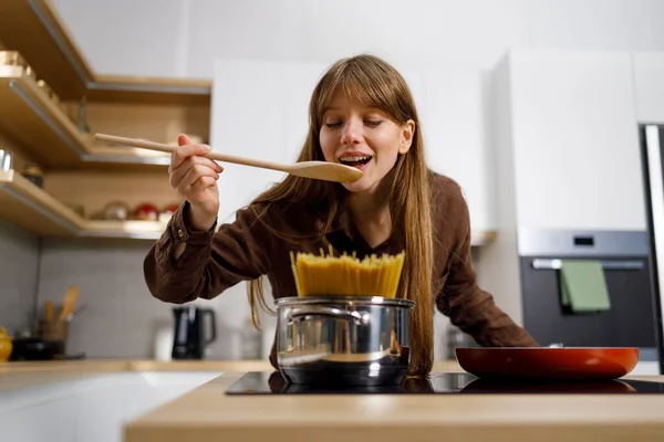 Mujer Joven Está Degustando Alimentos Mientras Cocina Cocina Casa — Foto de Stock