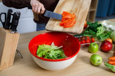 Kadın kaseye doğranmış biber atıyor. Sağlıklı beslenme, vejetaryen yemek, yemek pişirme, diyet konsepti