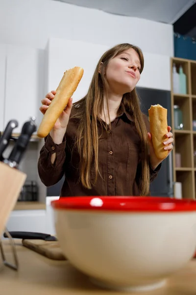 Chica Hambrienta Comiendo Una Baguette Mientras Cocina Cocina —  Fotos de Stock