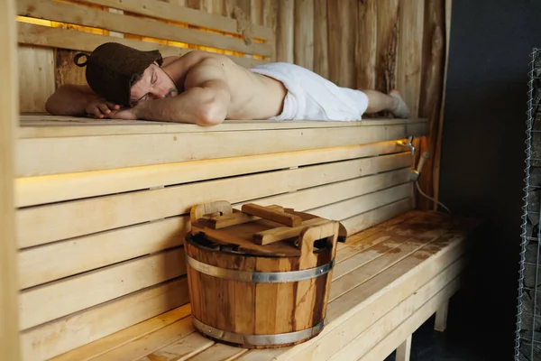 Man Met Een Witte Handdoek Ligt Ontspant Houten Sauna — Stockfoto