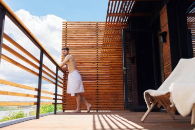 Kaplıcadaki terasta dinlenen yakışıklı adamın yan görünüşü