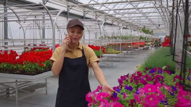 Çiçek Bahçesindeki Akıllı Telefondan Konuşan Kadın Çiçekçi — Stok video