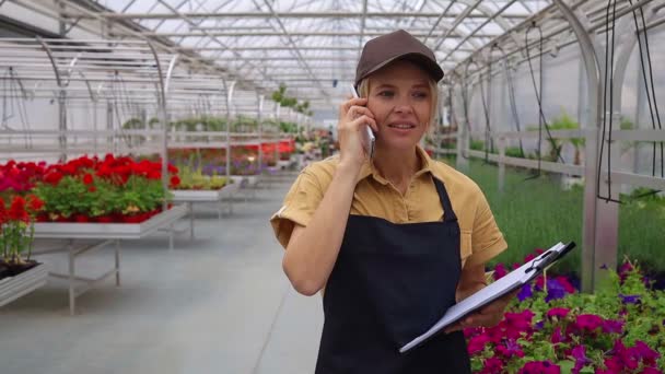 Female Garden Center Manager Taking Order Phone While Standing Flowers — Stock Video