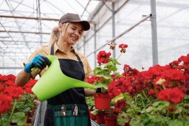 Bebek odasında çiçekleri sulayan kadın