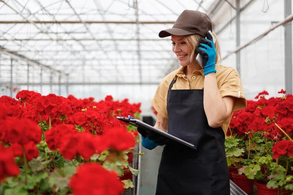 Női Dolgozó Üvegház Virágokkal Vesz Egy Megrendelést Egy Ügyfél Telefonon — Stock Fotó