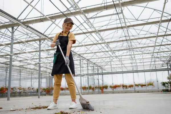 Pretty Woman Gardener Cleans Greenhouse Sweeping Rubbish Broom Brush — Stockfoto