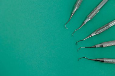 Closeup view of periodontal scalers on green background, dental instruments