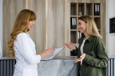 Doctor and patient discussing medical problems on the receprion in clinic